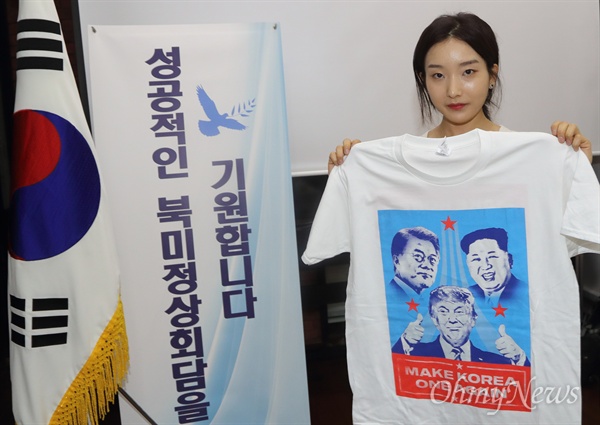 김정은 북한 국무위원장과 도널드 트럼프 미국 대통령의 역사적인 첫 북미정상회담이 예정된 12일 오전 싱가포르 한인회 사무실에서 교민이 두 정상의 성공적인 만남을 기원하며 제작된 티셔츠를 들어보이고 있다.