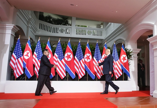 역사적인 첫 북미정상회담이 열린 12일 오전 싱가포르 센토사 섬 카펠라호텔에서 김정은 국무위원장과 트럼프 대통령 등이 악수하기 위해 걸어가고 있다.
