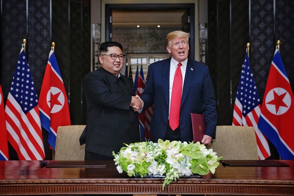 역사적인 첫 북미정상회담이 열린 2018년 6월12일 오후 김정은 국무위원장(왼쪽)과 트럼프 대통령. 공동 합의문에 서명을 마친 뒤 악수하고 있다.