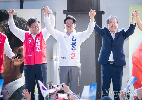  자유한국당 홍준표 대표가 선거를 하루 앞둔 12일 오후 서울 중구 대한문 앞에서 김문수 서울시장 후보 유세에서 후보자와 함께 손을 들어 올리고 있다.