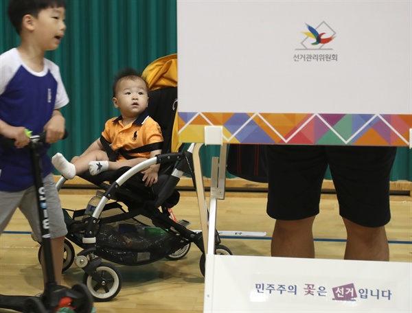 6.13 전국동시 지방선거가 실시된 6월 13일 오전 서울 서초구 반포1동 제2 투표소가 설치된 원천중학교에서 아빠와 함께온 어린이들이 투표 모습을 보고 있다. 