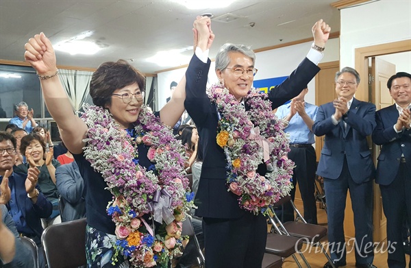 박종훈 경남도교육감 후보는 6월 13일 저녁 선거사무소에서 꽃다발을 받고 손을 들어 보이고 있다.