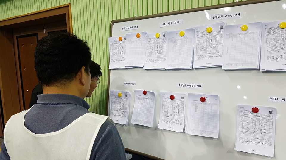 서산시민체육관에서 6.13 지방선거 개표가 진행되는 가운데, 서산시선관위는 개표현황을 실시간으로 게시하고 있다. 한 참관인이 게시판을 살펴보고 있다.  