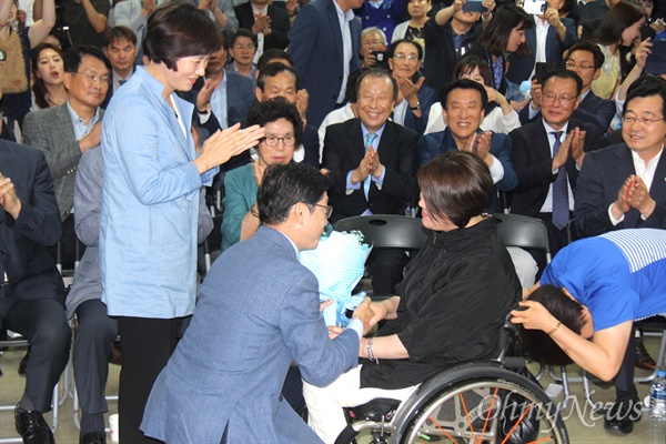 더불어민주당 김경수 경남도지사 후보가 당선이 유력시 된 14일 오전 1시경 선거사무소에서 휠체어를 탄 지지자로부터 꽃다발을 받고 있다.