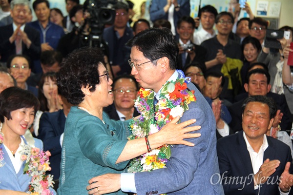 더불어민주당 김경수 경남지사 후보의 어머니가 14일 새벽 당선이 확실시 되자 선거사무소에서 아들을 안아주고 있다.