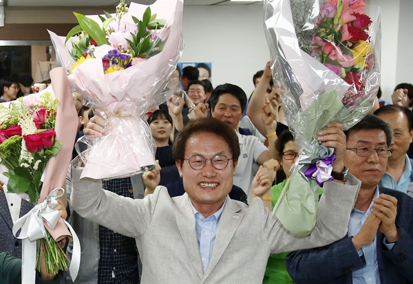 조희연 서울시교육감 후보가 13일 오후 서울 서대문구의 선거사무실에서 개표결과를 지켜보다 당선이 유력시되자 꽃다발을 받고 포즈를 취하고 있다. 