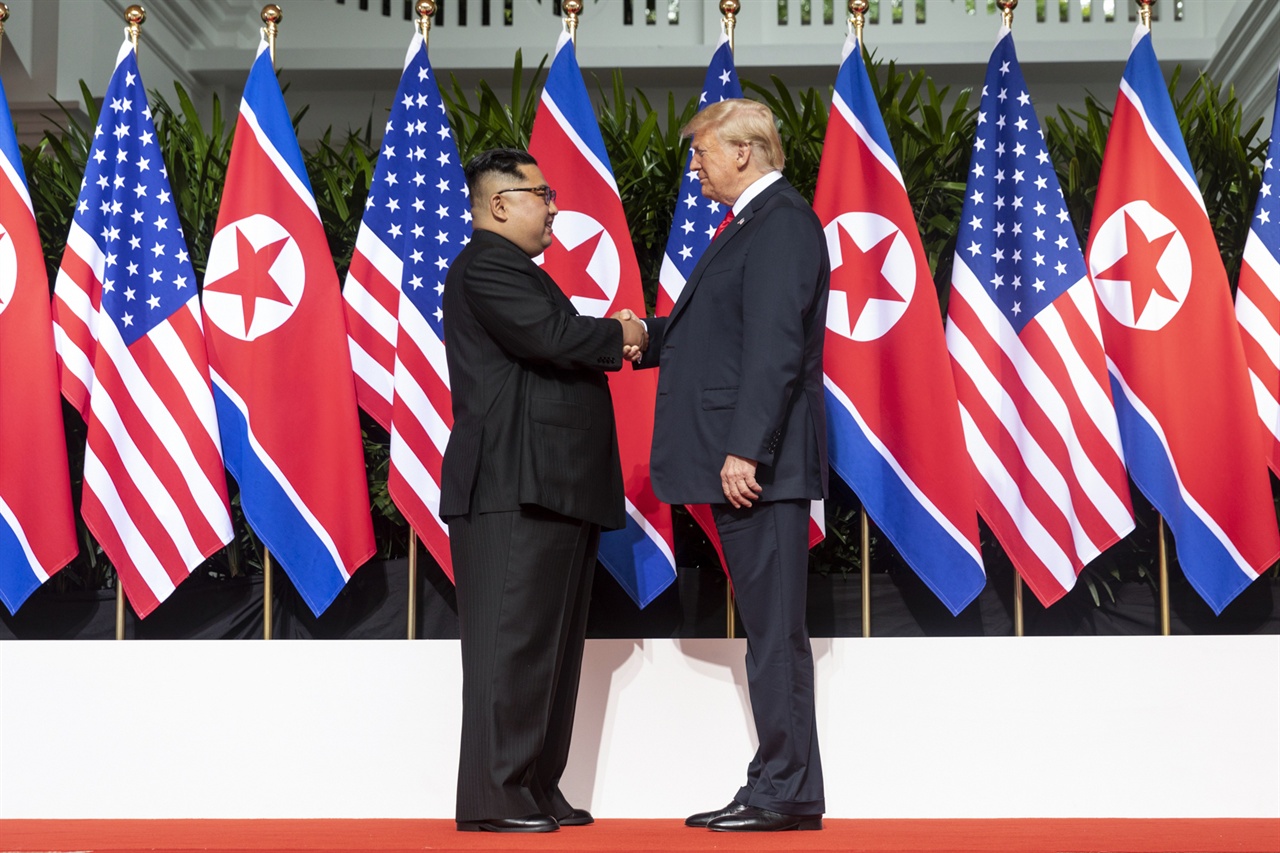 트럼프 대통령과 김정은 위원장이 지난 6월 12일 싱가포르 북미정상회담을 
갖기 위해 첫 만남과 악수를 나누고 있다. 백악관이 공식 배포한 사진