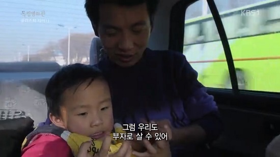  쿤은 베이징 시내를 달리는 택시 안에서 네 살배기 아들 치치(왼쪽)에게 "돈을 많이 벌어야 여기서 살 수 있다"고 말한다. 
