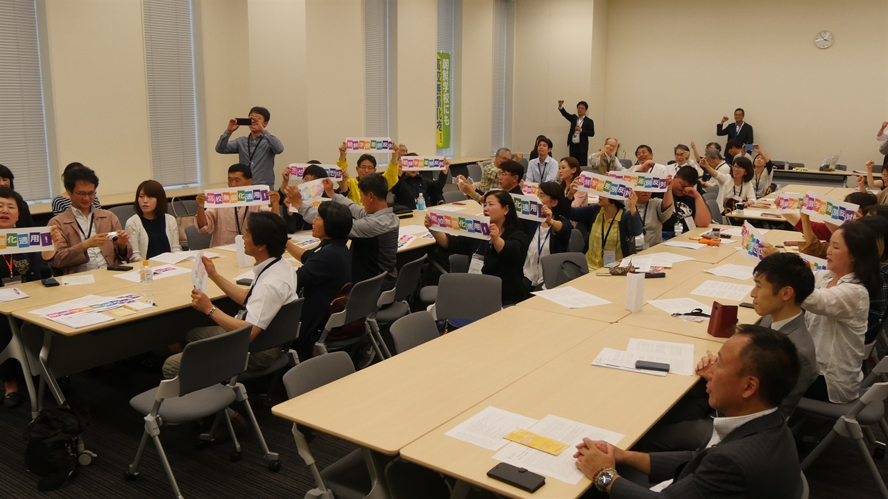   항의방문단이 '조선학교 차별반대', '고교무상화적용을' 등이 적힌 카드를 들고 구호를 외치고 있다.