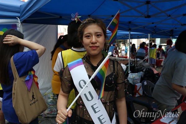  23일 오후 대구 동성로에서 열린 대구퀴어축제에 참가한 한 참가자가 무지개깃발을 머리에 꽂고 퀴어라고 쓴 어깨띠를 두르고 서 있다.