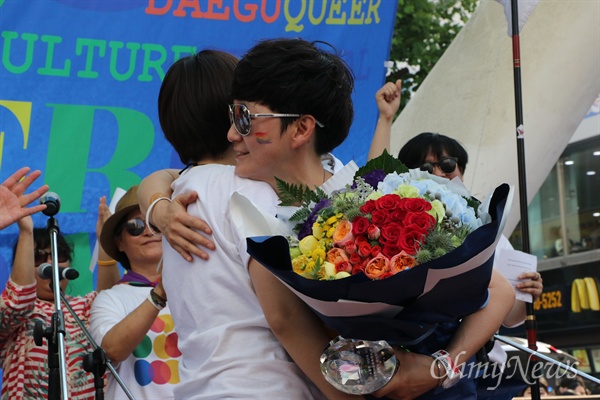 23일 오후 대구 중구 동성로에서 열린 퀴어축제에서 배진교 조직위원장이 감사패와 꽃다발을 받아든 뒤 포옹을 하고 있다.