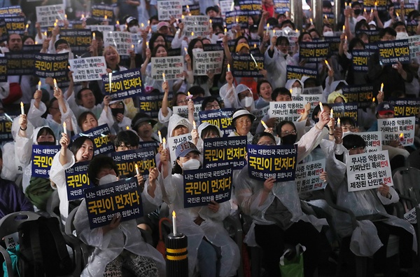 30일 오후 서울 종로구 동화면세점 앞에서 열린 난민법과 무사증(무비자) 제도 폐지 집회에서 참가자들이 손팻말을 들고 있다.