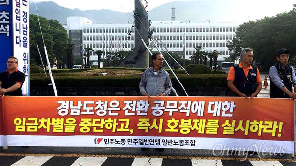 민주노총(경남)일반노동조합 조합원들이 7월 2일 아침 경남도청 정문 앞에서 펼침막을 들고 서 있다.