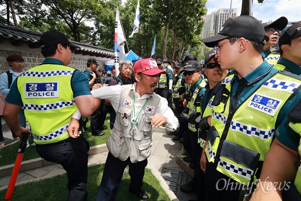 태극기와 성조기를 든 보수단체 회원들이 3일 오전 서울 덕수궁 대한문앞에서 금속노조 쌍용차지부 고 김주중 조합원 분향소 설치에 격렬하게 항의하고 있다.