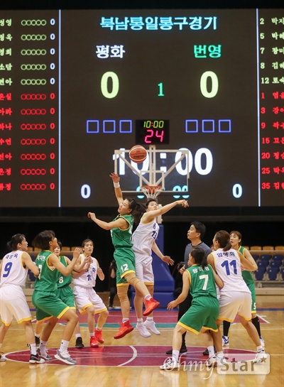 일 평양 류경정주영체육관에서 개최된 남북통일농구경기에서 여자 ‘평화’팀과 ‘번영’팀이 혼합경기에서 점프볼을 하고 있다.