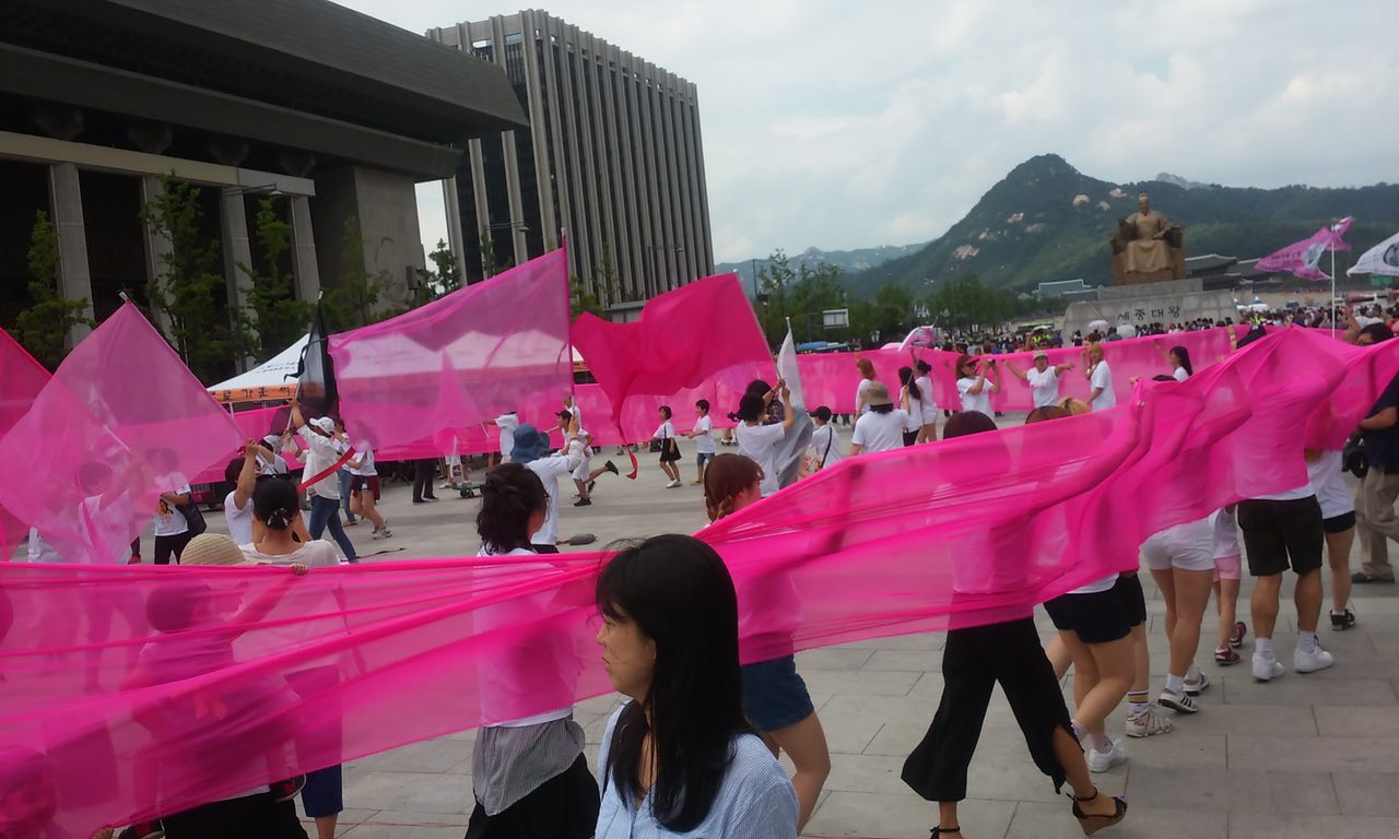  평화어머니회 회원들이 시민들과 함께 플레시 몸을 평치고 있다.