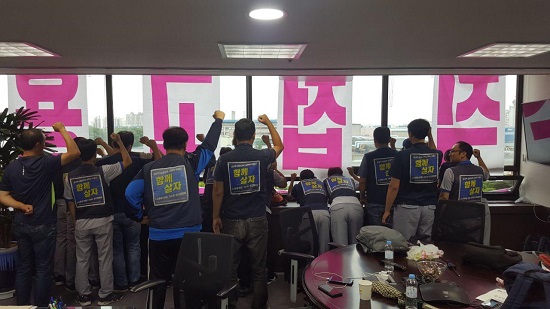 한국지엠 부평 본관 사장실을 점거 중인 비정규직노동자들이 본관 앞에서 집회 중인 비정규직지회와 호응해 '정규직 전환'을 촉구하고 있다.