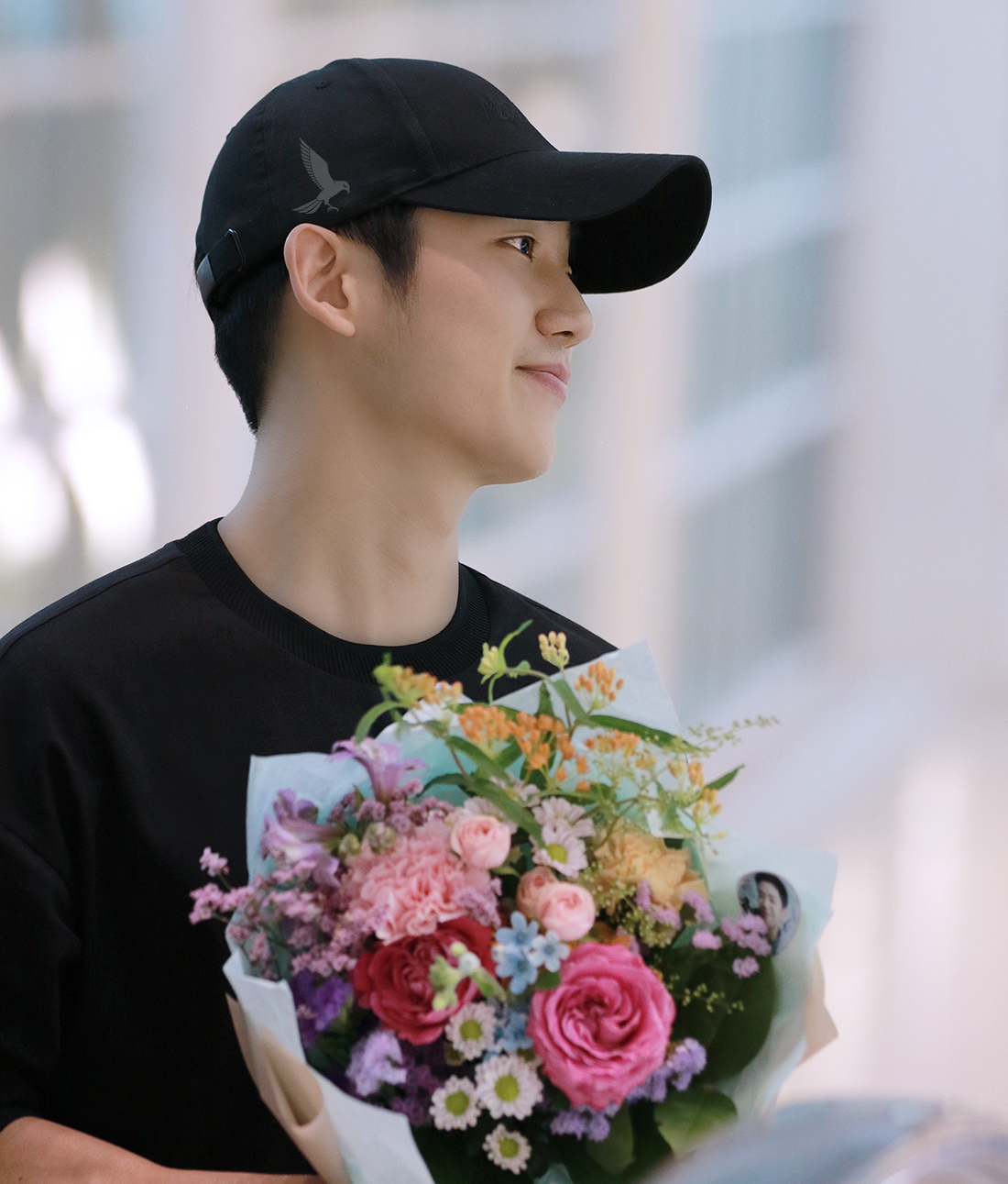  배우 정해인이 팬이 건넨 꽃다발을 받고 밝게 웃고 있다.