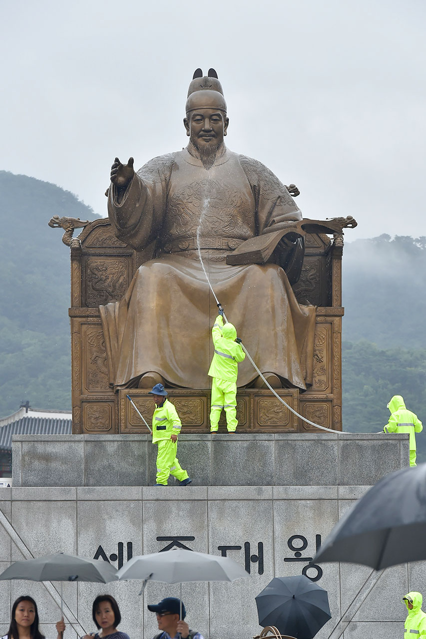 세종대왕님! 시원하시지요? 서울시 관계자들이 9일 오후 서울 세종로 광화문광장에 세워져 있는 세종대왕 동상의 묻은 때를 벗겨내기 위해 물과 대걸레를 이용해 깨끗하게 세척작업을 진행 있다. 2018.7.9