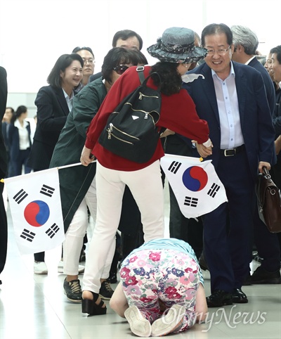 6.13 지방선거 패배의 책임을 지고 물러난 홍준표 전 자유한국당 대표가 11일 오후 인천국제공항 제2여객터미널에서 출국하는 도중 배웅나온 한 지지자가 홍 전 대표를 향해 큰절을 하고 있다.