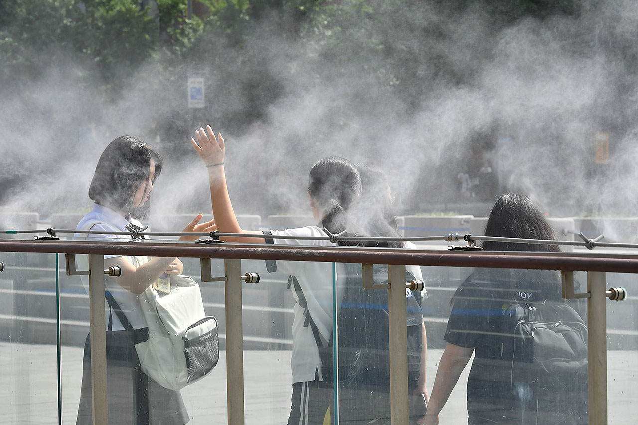 전국 대부분의 지역에서 30도를 웃돌며 찜통더위가 기승을 부리고 있는 가운데 13일 오후 서울시 세종로 광화문광장을 찾은 학생들이 쿨 스팟 (Cool Spot) 을 맞으며 더위를 식히고 있다. '쿨스팟(Cool Spot)'은 깨끗한 수돗물을 고압으로 분사해 생긴 작은 물방울이 증발하면서 주위의 온도를 2~3도 가량 낮추는 시설이다. 2018.7.13