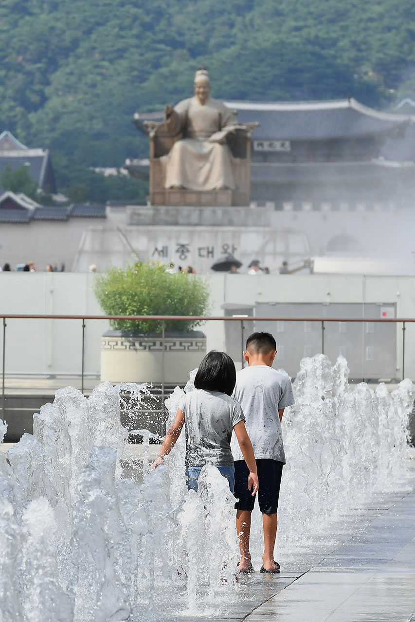 전국 대부분의 지역에서 30도를 웃돌며 찜통더위가 기승을 부리고 있는 가운데 13일 오후 서울 세종로 광화문광장을 찾은 어린들이 광장 분수대에서 뿜어져 나오는 물을 맞으며 더위를 식히고 있다. 2018.7.13