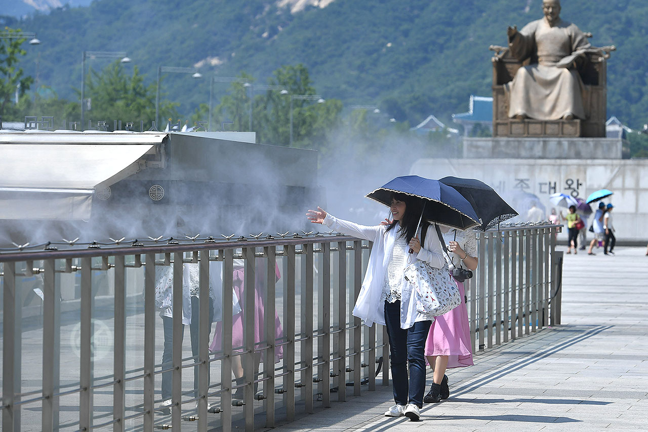 서울에 올 여름들어 처음으로 폭염경보가 발효된 16일 오후 서울 광화문광장을 찾은 외국인들이 쿨 스팟 (Cool Spot) 을 맞으며 더위를 식히고 있다. 2018.7.16