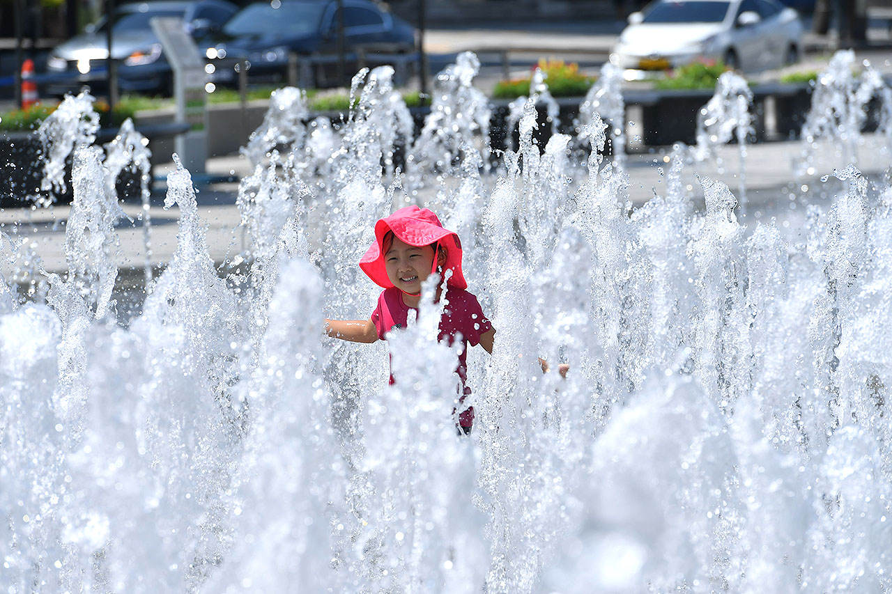 서울에 올 여름들어 처음으로 폭염경보가 발효된 16일 오후 광화문광장을 찾은 한 어린이가 광장 분수대에서 뿜어져 나오는 물줄기 속을 뛰어다니며 더위를 식히고 있다. 2018.7.16