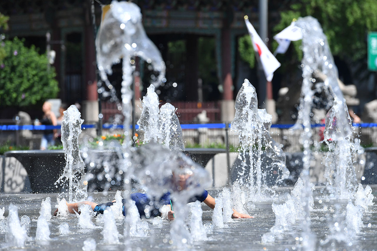 서울에 올 여름들어 처음으로 폭염경보가 발효된 16일 오후 광화문광장을 찾은 한 어린이가 광장 분수대에서 뿜어져 나오는 물줄기를 맞으며 더위를 식히고 있다. 2018.7.16