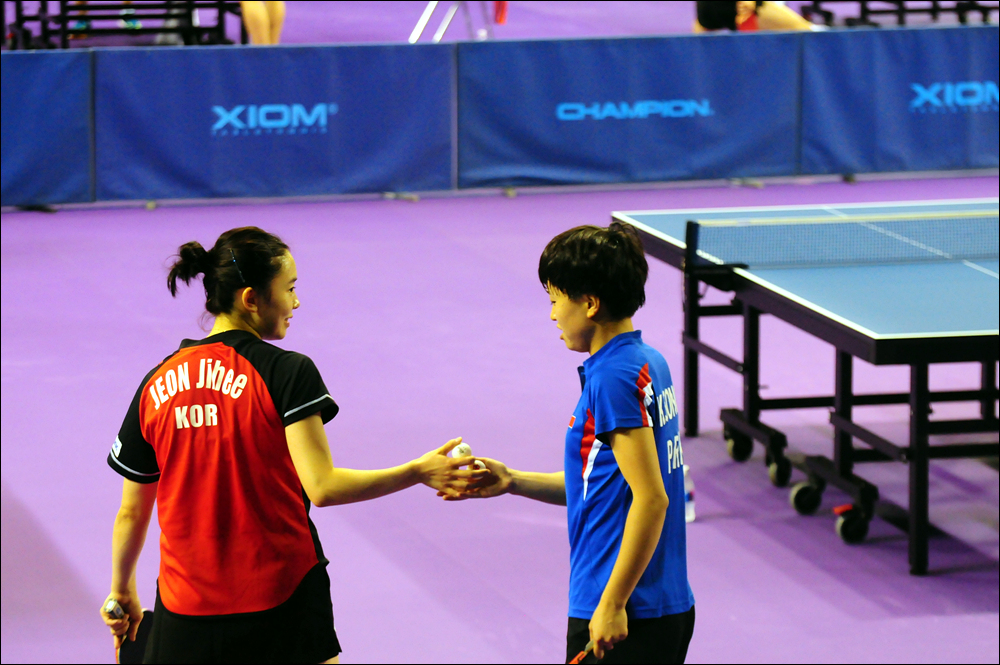 연습 도중 남측의 전지희 선수가 북측의 김송이 선수에게 탁구공을 주며 이야기를 나누고 있다.