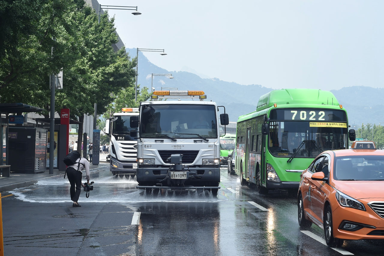  연일 찜통더위가 이어지고 있는 가운데 18일 오후 서울 세종로 일대에서 물청소차가 도로에 물을 뿌리며 뜨겁게 달아오른 열기를 식히고 있다. 서울시는 낮 최고기온이 32도 이상인 폭염이 발생하면 도로 살수(물 뿌리기)작업을 강화하여 실시할 계획이다. 2018.7.18
