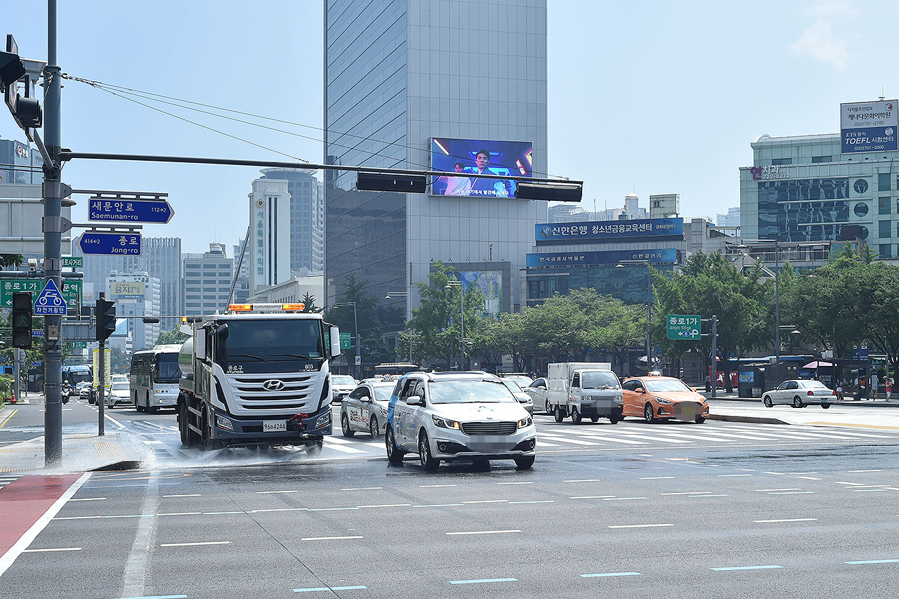  연일 찜통더위가 이어지고 있는 가운데 18일 오후 서울 세종로 일대에서 물청소차가 도로에 물을 뿌리며 뜨겁게 달아오른 열기를 식히고 있다. 서울시는 낮 최고기온이 32도 이상인 폭염이 발생하면 도로 살수(물 뿌리기)작업을 강화하여 실시할 계획이다. 2018.7.18