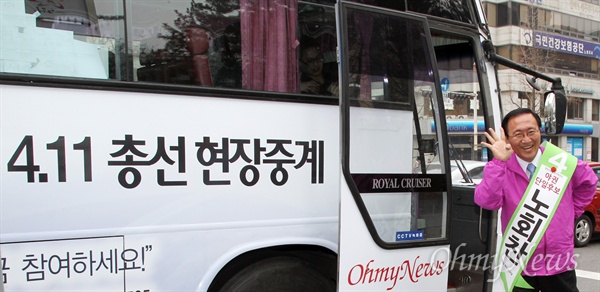 서울 노원병에 출마한 노회찬 통합진보당 후보가 29일 <오마이뉴스> 총선버스에서 내리며 '기호4번'을 그려보이며 지지를 당부하고 있다.