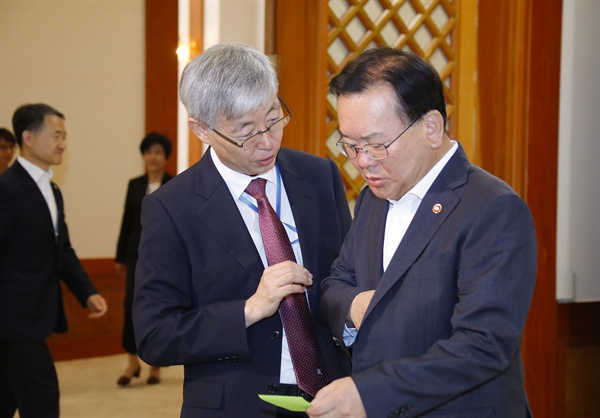 김부겸 행정안전부 장관(오른쪽)과 김현철 대통령 경제보좌관(왼쪽)이 이 24일 오전 청와대에서 열린 국무회의에 앞서 차담회에서 만나 메모를 보며 대화하고 있다.