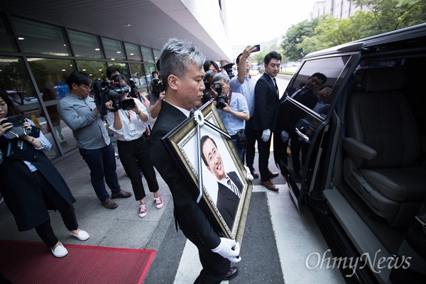  26일 오전 서울 서대문구 신촌세브란스병원 장례식장에 마련된 고 노회찬 정의당 원내대표의 빈소에서 김영훈 정의당 노동이당당한나라 본부장이 노 의원 영정을 안고 고인이 탑승했던 차량에 오르고 있다. 영정은 노 의원의 지역구인 창원으로 향한다.