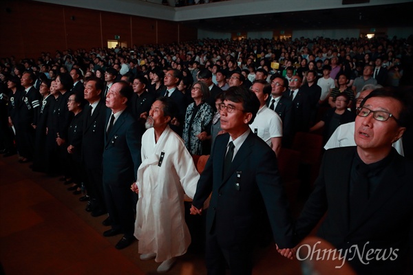 26일 오후 서울 서대문구 연세대 대강당에서 열린 '고 노회찬 국회의원 추도식'에서 부인 김지선씨, 정의당 이정미 대표, 심상정 의원, 강기갑 전 의원, 유시민 작가 등 참석자들이 손을 맞잡고 '그날이 오면'을 합창하고 있다.