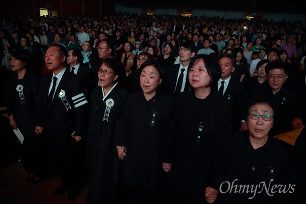 26일 오후 서울 서대문구 연세대 대강당에서 열린 '고 노회찬 국회의원 추도식'에서 부인 김지선씨, 정의당 이정미 대표, 심상정 의원 등 참석자들이 손을 맞잡고 '그날이 오면'을 합창하고 있다.