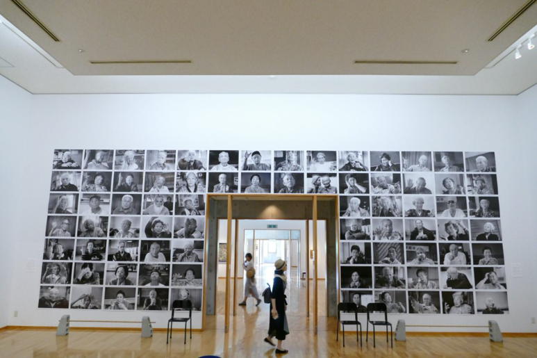 오키나와전도 그림을 마주보고 있는 오키나와전 생존자들의 사진