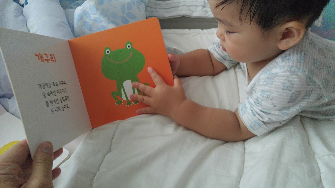침대에 엎드려 아빠와 함께 책 읽기