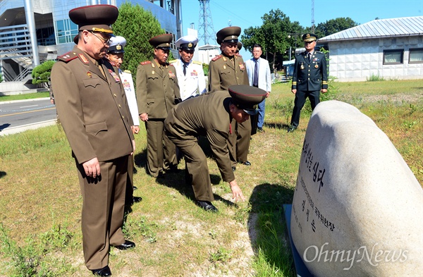 제9차남북장성급군사회담 북측 수석대표인 안익산 육군 중장과 대표단 일행이 31일 오전 판문점 남측지역에서 지난 남북정상 회담 때 기념 식수하며 세운 표석을  살펴보며 잡초를 뽑고 있다.