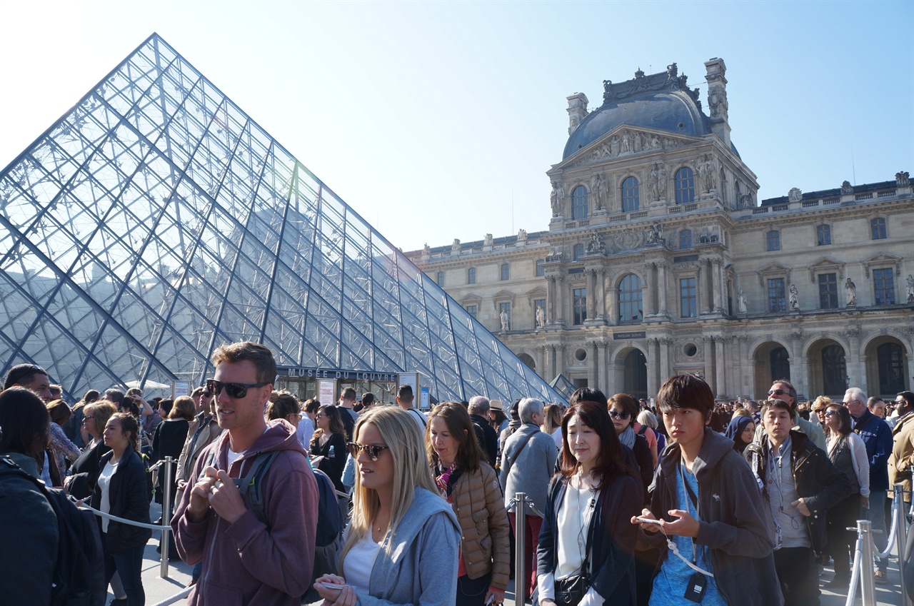 루브르 박물관 입장을 위해 유리 피라미드 앞에 줄을 선 관람객들