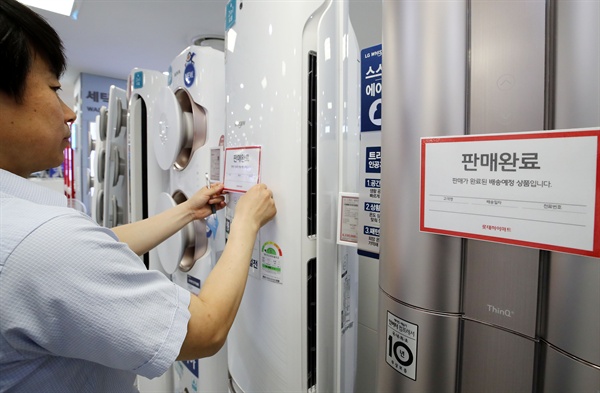 7월 29일 서울의 한 전자제품 판매점에서 직원이 판매완료된 에어컨에 안내문을 붙이고 있다.