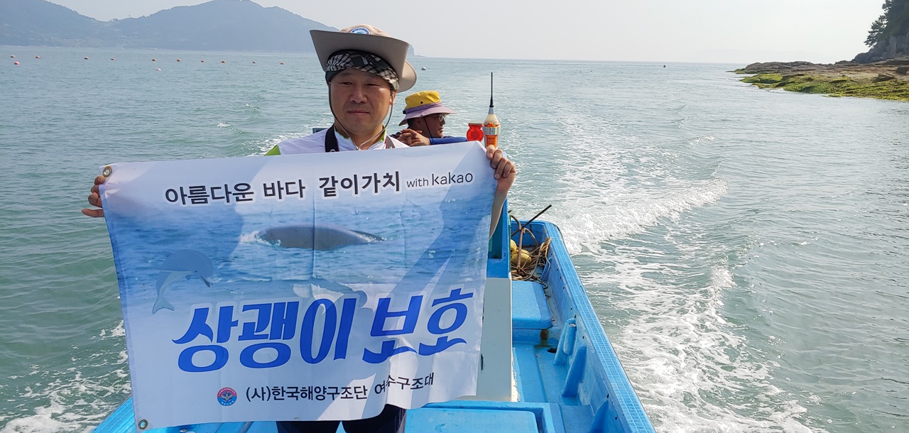 한국해양구조협회 여수구조대 박근호 대장이 상쾡이가 가장 많이 출몰하는 자신의 고향인 월호도 앞에서 현수막을 펼친 모습