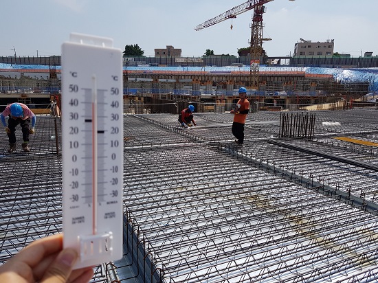 지난 2일 경기도 수원시 권선구의 한 공사현장에서 일하는 건설노동자들. 온도계가 섭씨 40도를 가리키고 있다.