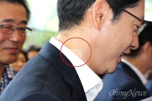 김경수 경남도지사가 8월 10일 새벽 특검 조사를 받고 나오다 폭행을 당해 목 부분에 '밴드'(원안)를 붙이고 있다.