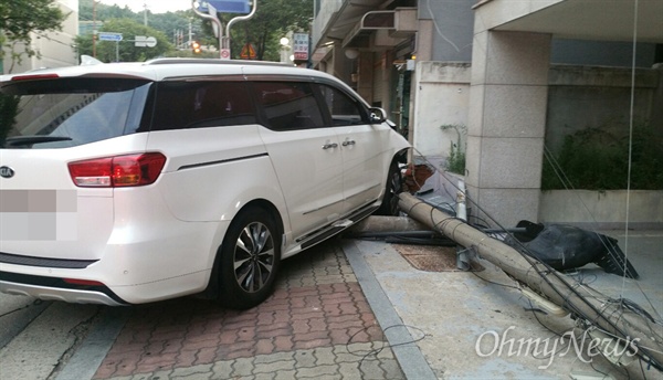 차가 돌진해 전봇대를 들이 받고 담벼락을 파손했다