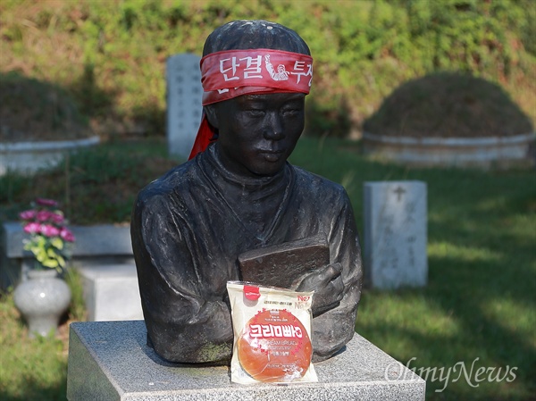 '전태일 열사와 크림빵' 근로기준법을 품고 있는 전태일 열사의 흉상앞에 동생이 올려놓은 크림빵 하나.