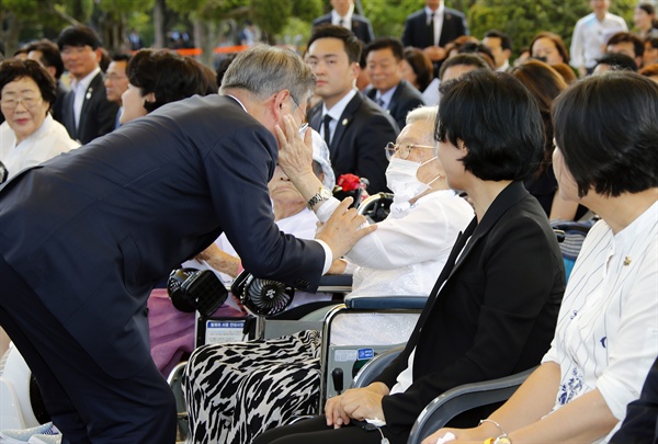 문재인 대통령이 14일 충남 천안 국립 망향의 동산에서 열린 일본군 위안부 피해자 기림의 날 기념식에 입장하며 김경애 할머니와 인사를 나누고 있다.