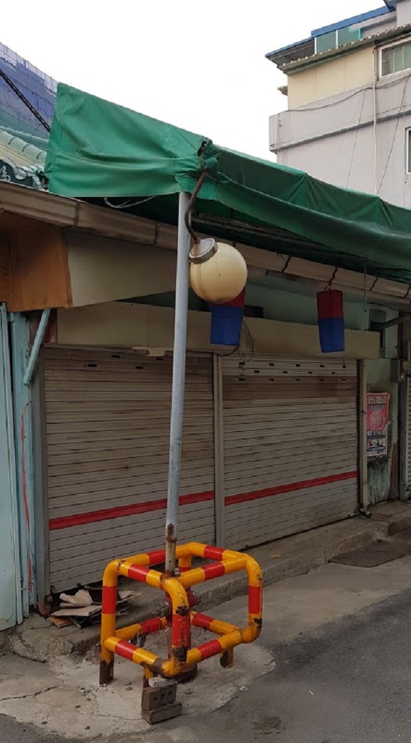 한 가게에서 가게 처마를 지탱하기 위해 소화전 보호대에 기둥을 용접해 놓은 모습