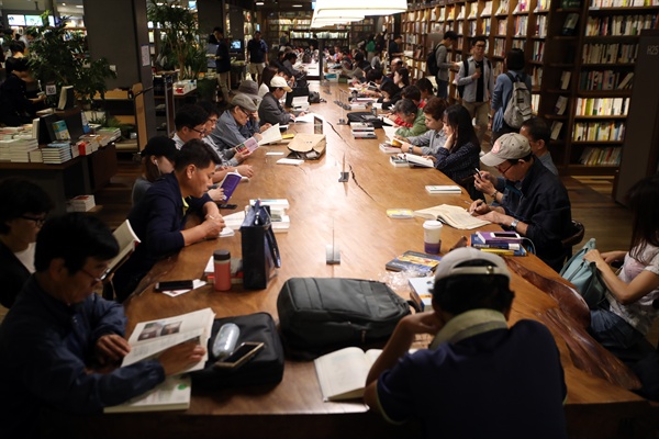 서울 광화문 교보문고에 놓인 대형 테이블에서 책을 보고 있는 사람들